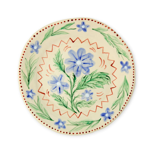 Hand-painted ceramic plate by artist Sasha Compton for Shop Kit Kemp, featuring a central cluster of blue forget-me-nots surrounded by a scalloped terracotta border and delicate floral motifs on an off-white background.