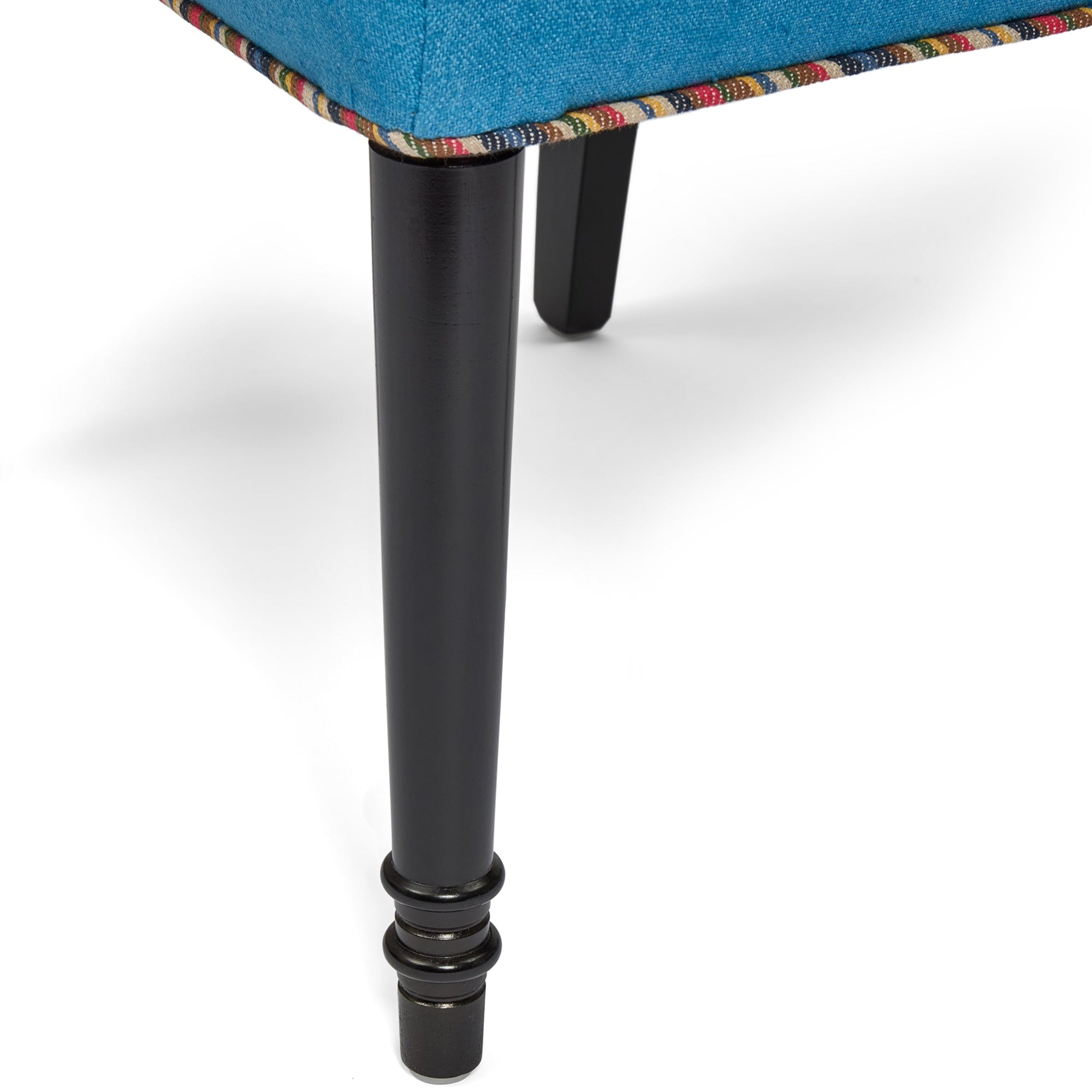 Close-up of a chair leg with a colorful fabric seat on a white background