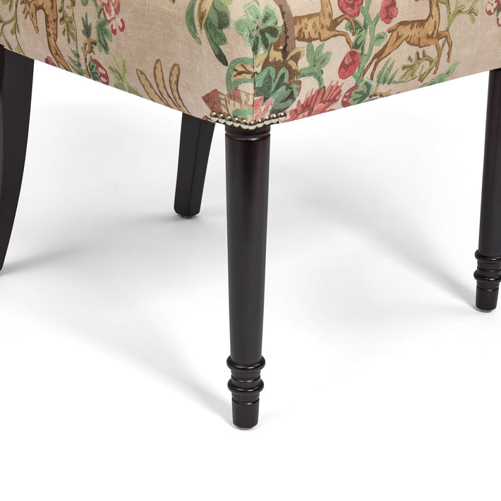 Chair with floral and deer patterned fabric on a white background
