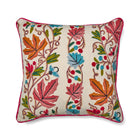 Wool hand embroidery design with vines, leaves and berries, in energetic orange, pink, blue and green tones on Kit Kemp Design Studio cushion, edged in pink piping.
