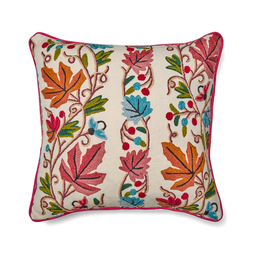 Wool hand embroidery design with vines, leaves and berries, in energetic orange, pink, blue and green tones on Kit Kemp Design Studio cushion, edged in pink piping.