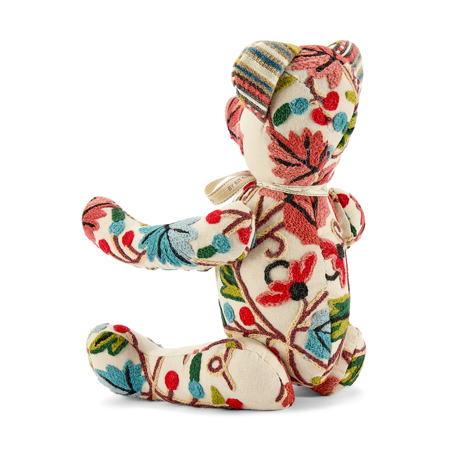 A luxury patchwork bear featuring the vibrant Pierre Frey Fronsac woollen chain stitch design. The bear's body is covered in a rich, textured striped pattern of red, teal, and green botanical motifs, complemented by multi-coloured striped ears and paws that emphasize its artisanal quality.