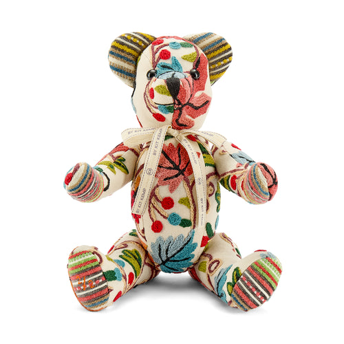A limited-edition Sycamore Willow Bear meticulously crafted from Pierre Frey Fronsac fabric. The bear features a sophisticated woollen chain stitch embroidery on a cream linen base, showcasing a colourful and naïve pattern of intertwined foliage and floral bouquets.