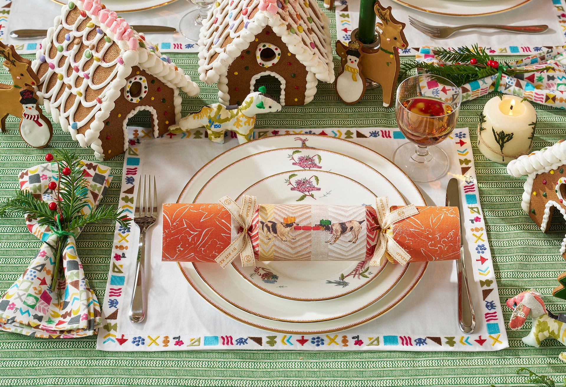 Decorative Christmas festive table with Kit Kemp signature Mythical Creatures tableware, crackers, potato print napkins and placemats, cutlery, and refined glassware. Exclusively at Shop Kit Kemp.