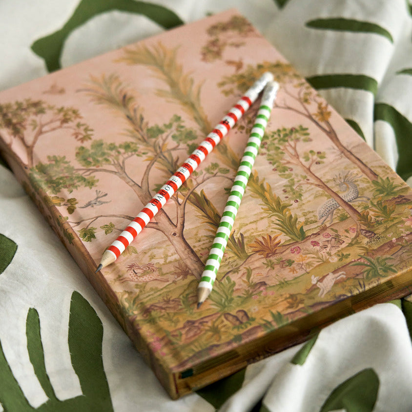 A bound hardcover notebook features Kit Kemp’s beloved Tall Trees design. B5 size, paired with striped Firmdale pencils, sold in pack of six.