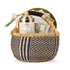 Tall Trees Tea gift basket containing a mug, a tea tin, and a Geo side plate, presented in a woven basket, secured with a ribbon, ready for gifting to any tea lover. 