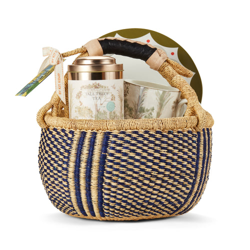 Tall Trees Tea gift basket containing a mug, a tea tin, and a Geo side plate, presented in a woven basket, secured with a ribbon, ready for gifting to any tea lover. 