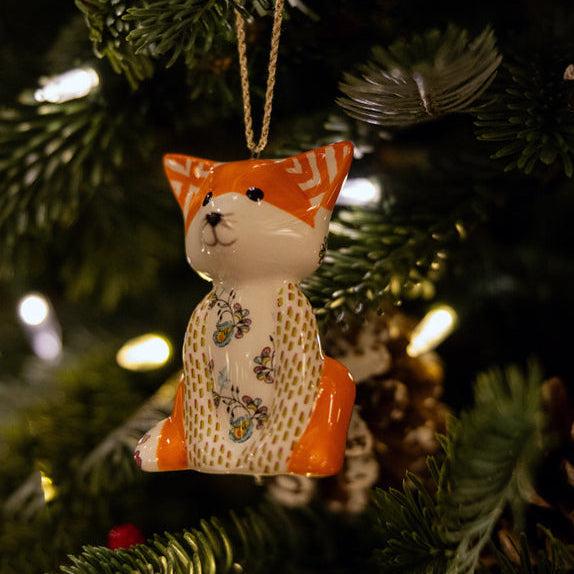 The Kit Kemp for Spode Patchwork Animal Tally Ho Fox fine china Ornament. This sophisticated decoration features a sitting fox with a vibrant orange and white face, a patterned head with subtle gold detailing, and a white body decorated in a green dotted, floral patchwork design. A truly unique, stylish, and high-quality collectible piece that brings designer style to your Christmas tree.