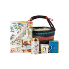 A colourful Shop Kit Kemp woven basket with a leather handle, containing a Mythical Hallway jigsaw puzzle, a Mind Over Matter mug, and a Mythical Creatures tea caddy tin containing 20 tea bags, a perfect gift for winter and cosy days.
