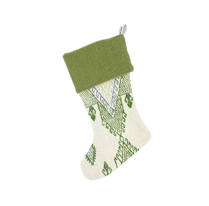 Artisan-style Christmas stocking featuring Kit Kemp's 'Travelling Light' weave. The intricate geometric design in shades of crisp green and blue on an ivory background offers a fresh, earthy take on festive decor. A luxurious and unique piece, perfect for sophisticated holiday gifting.