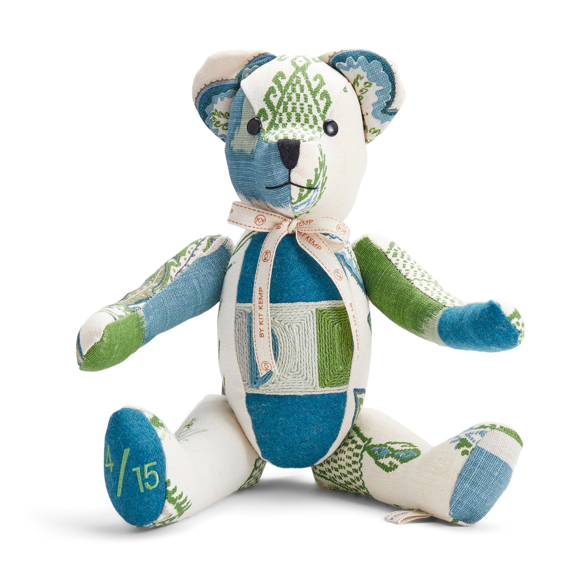 The Travels Willow Large Bear features fabric combinations in green, white and blue, offset with embroidered waistband and branded Kit Kemp ribbon. Ideal as collector's item and adorable gift for any age.