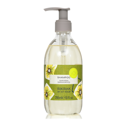 A 295ml plastic bottle of shampoo with pump dispenser scented with Gardenia Sandalwood. Label has a green friendly flowers design applied.