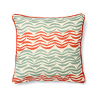 Design Studio cushion featuring a bold, woven pattern of orange and grey waves arranged in a subtly irregular striped formation. The textured fabric is framed by a vibrant, contrasting tangerine piped edge, highlighting the rhythmic and graphic nature of the design.