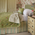 A weekend collection bedspread set in a cosy bedroom with pink floral wallpaper 