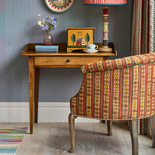 The West Timber Tub Chair embraces you in its curved arms and boasts a rollover top and elegant wooden legs. Upholstered in Kit Kemp's 'Hotline', a vibrant, fun fabric from the collection created in collaboration with Christopher Farr, it takes on a new dynamic energy, with its textured stripe effect, and intricate woven stitch detailing in earthy terracotta tones.
