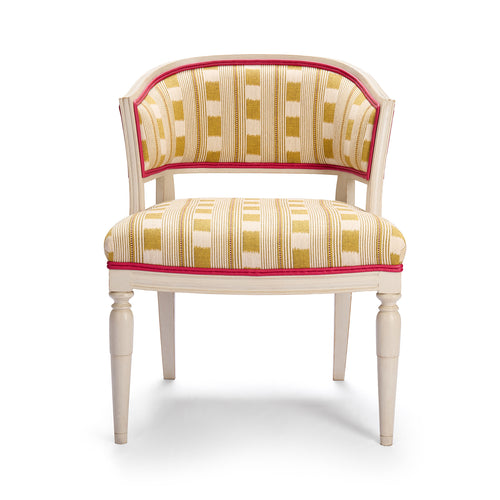 Whitby Chair in Lost and Found lemon fabric, showing hand carved solid wood legs in off white with a double pink leather trim piping.