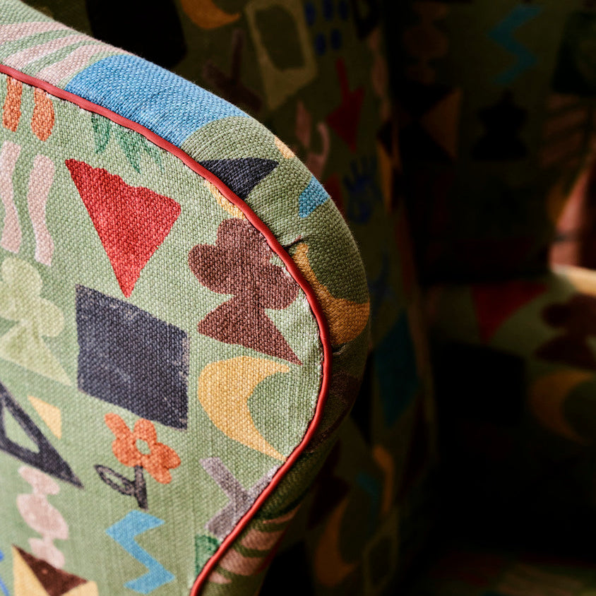 Kit's Wing Chair in Potato Print Green close up detail with contrasting orange leather piping.