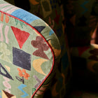 Kit's Wing Chair in Potato Print Green close up detail with contrasting orange leather piping.
