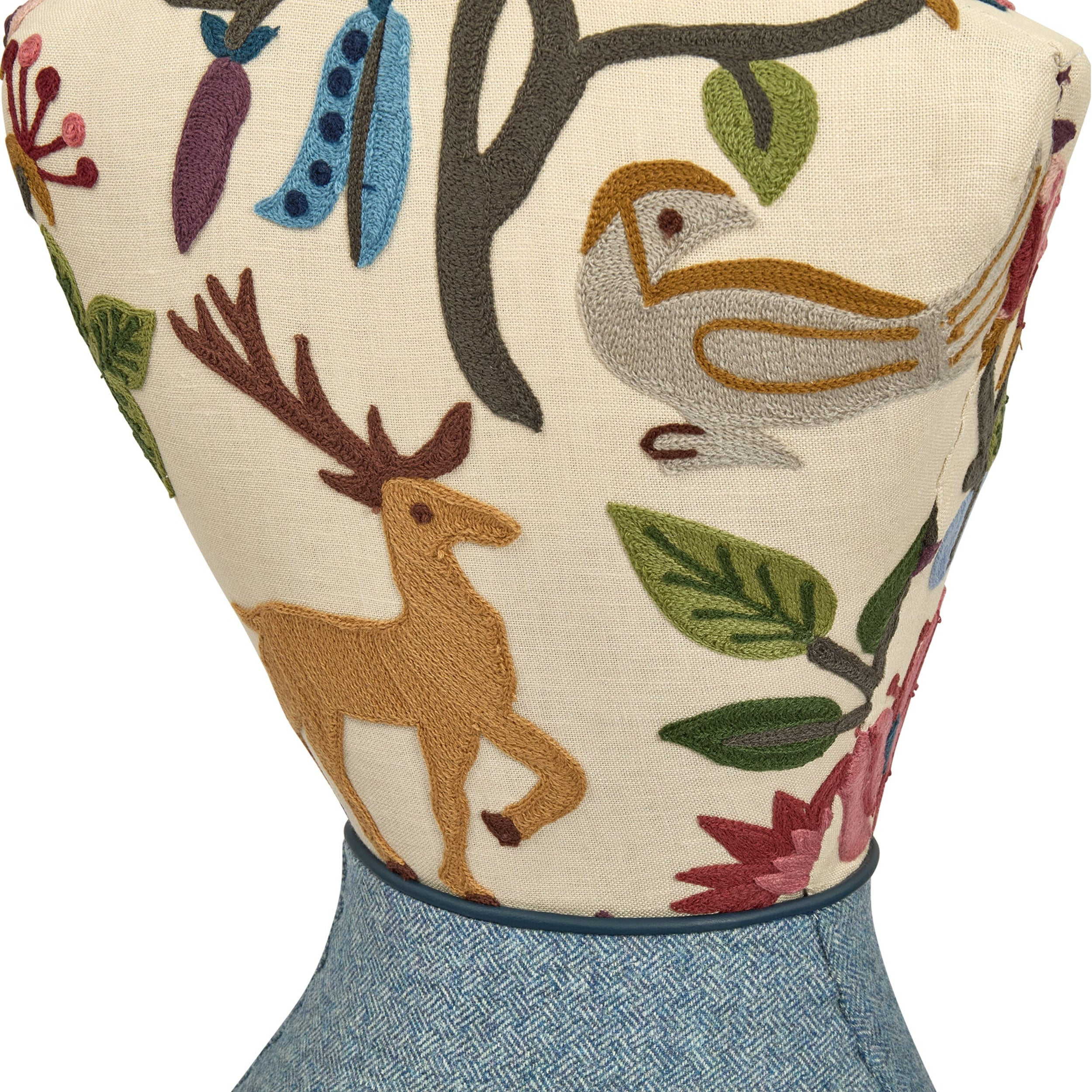 Decorative pillow with embroidered animals and plants on a white background