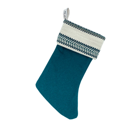 An elegant Christmas stocking featuring the distinct blue Woven Ribbon design in a tactile, woven texture. Ethically produced from fabric offcuts as part of a commitment to sustainable, zero-waste design.