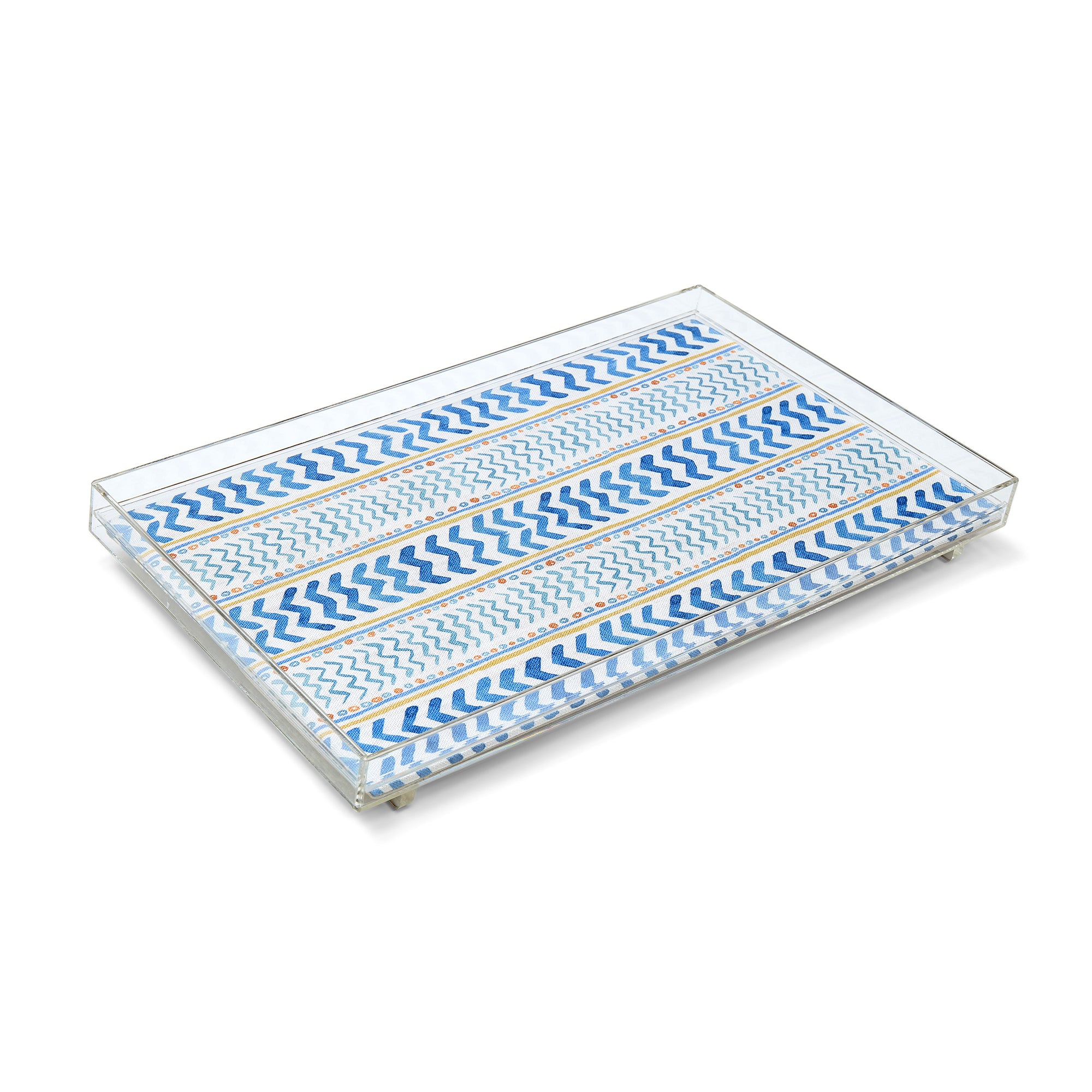 A rectangular Kit Kemp clear acrylic tray featuring an artisan fabric inlay of the "Wriggle Room" pattern. The design showcases playful, painterly blue geometric chevrons and stripes on a white background with subtle yellow accents. The tray is engineered for a premium weight and thickness, offering a sleek, stackable solution for styling ottomans or dining tables.