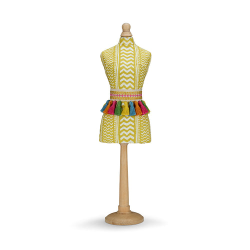 A decorative mini mannequin on a turned wooden pedestal. The torso is upholstered in yellow "Tweak" fabric, accented by a three-dimensional belt of pink, orange, blue, and green tassels that add texture and movement.