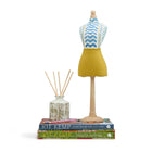 A decorative handmade mini mannequin by Kit Kemp. The paper-mâché torso is upholstered in a blue chevron "Wriggle Room" fabric, paired with a textured yellow linen skirt. 
