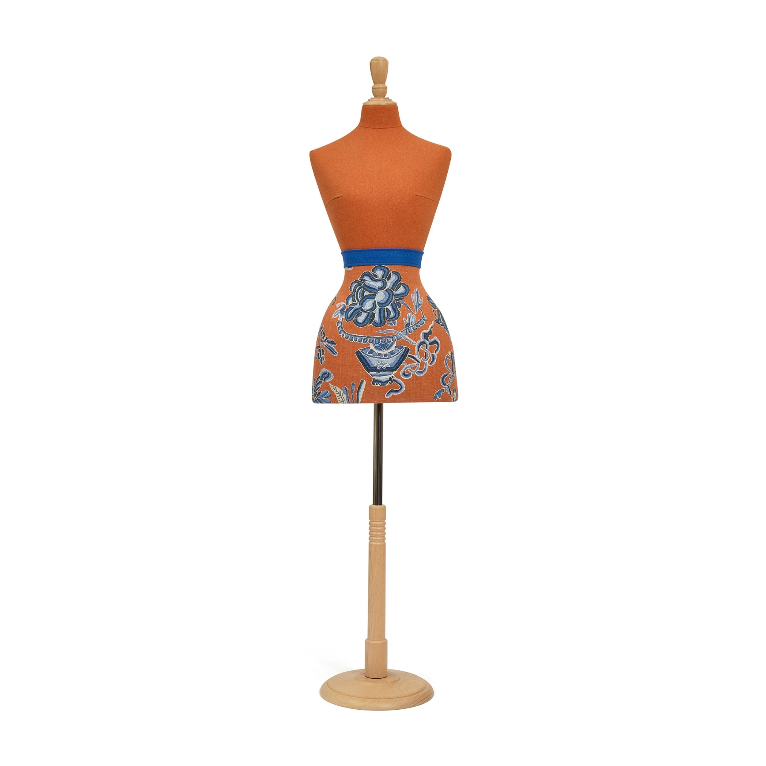 Mannequin wearing an orange apron with blue floral patterns on a white background