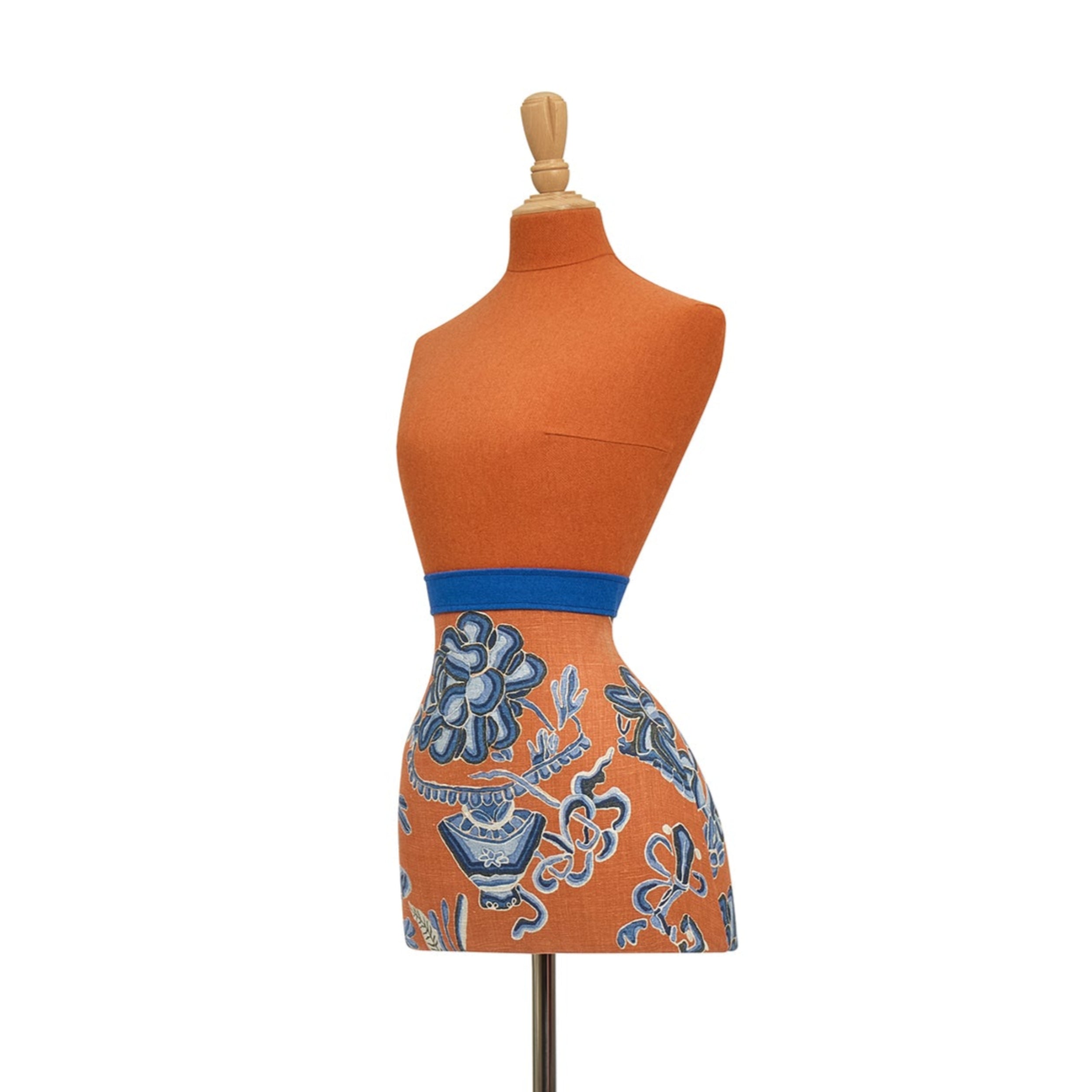 Mannequin wearing an orange skirt with blue floral pattern on a white background