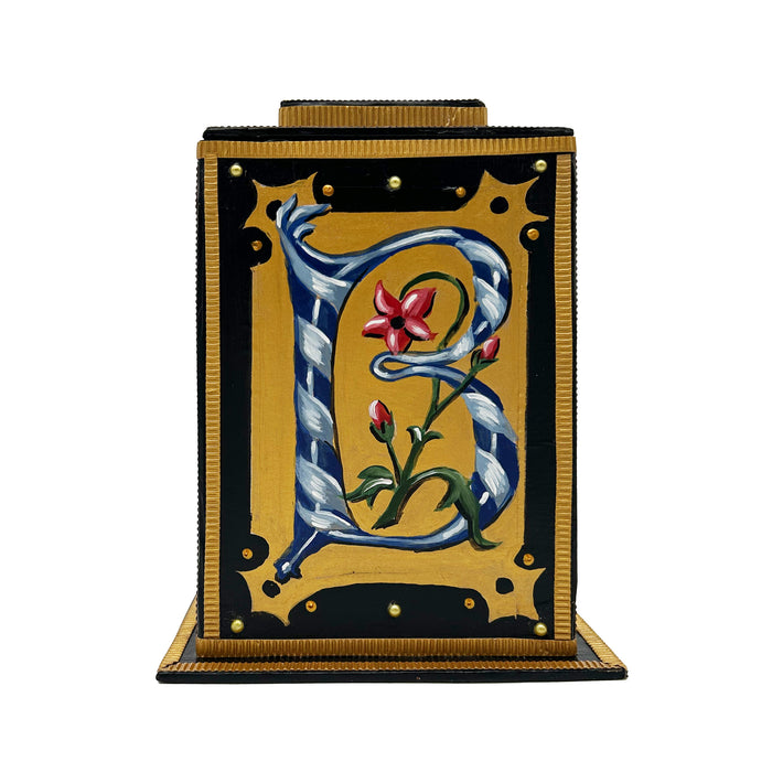 This black and gold alphabet box is decorated with a navy letter B in a heraldic decorative style, and embellished a red, blue and pearl jewelled lid. 