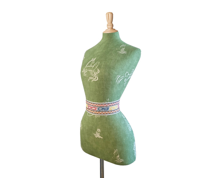 Side view of Mannequin with Kit Kemp's Friendly Folk basil green fabric for Andrew Martin with a Caravanne waist band