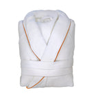 White bathrobe with orange piping detail folded.