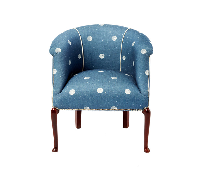 A tub chair upholstered in Kit Kemp's over the moon fabric in the denim colourway