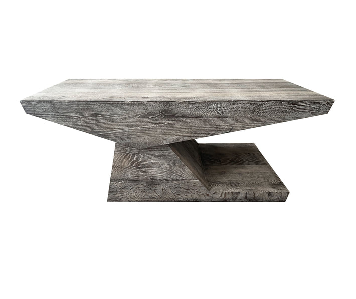 A side view of the Canter Lever coffee table, in Haymarket grey lime washed wood, showing the two triangular blocks of grey, lime-washed wood, counter-levered together on the side to to form this architectural, yet functional coffee table. Size:d60 x w120 x h45 cm / d 23.5 x w47.25 x d17.75