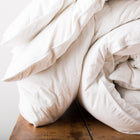 White rolled up white duvet with white cover with piped edges