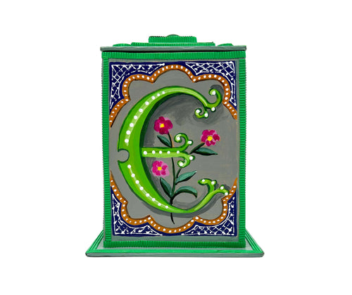 This bright green alphabet box is decorated with a green letter E in a heraldic decorative style, with a pink floral motif surrounded by blue trellis work and embellished with turquoise jewelled lid. 