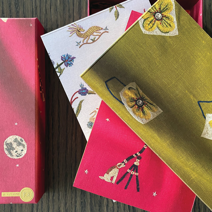 3 notebooks in three different Kit Kemp's designs for Chelsea Textiles: Friendly Flowers, Mythical Creatures and pink Moondog.