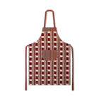 Kit Kemp's Lost and Found chequer board fabric in ruby and ecru, is made into an apron with large front pocket, shown dressed on a green mannequin.