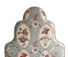 The Flora head board, is a tall upholstered headboard with 3 prominent arches, reminiscent of a Victorian Jelly Mould, pictured here upholstered in Kit Kemps Blue Chain Stitch material, with its abstract red, beige and pink abstract floral design, surrounded in ornate oval-like framework outlines.