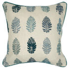 The image displays a cushion with a botanical design. The pattern features stylized stitched representations of fern-like plants in two colors, dark blue and a lighter blue grey, set against a neutral beige fabric background. 