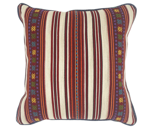 The Romany Weave Cushion has alternating stripe panels in deep reds, orange, navy and ecru, overstitched in delicate embroidered double crosses, in yellow, purple and green, with contrasting blue piping.