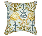 The image shows a decorative cushion with an intricate pattern. The pattern features a symmetrical layout with traditional motifs. The primary colors in the design are golden yellow, sky blue, and olive green, set against a light background. The central motif resembles a stylized, ornamental pineapple, flanked by scrolling vine-like elements and smaller decorative motifs that enhance the overall aesthetic appeal of the cushion.