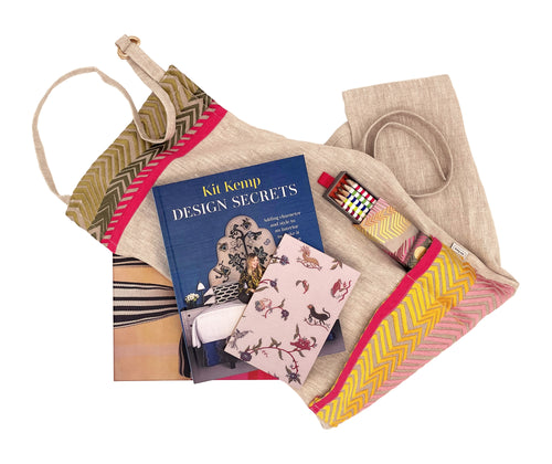 Boxed Gift , containing the pink bookend linen crafting apron (rolled), the Design Secrets By Kit Kemp, book, a box of pencils, and a green notebook.. everything you could need to get crafting.