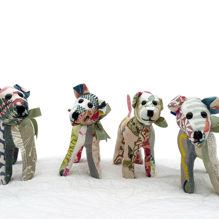 Group shot of 4 versions of the spring 2023 updated colours in Tiffany pooch, patchwork toy, standing on a white bedspread.