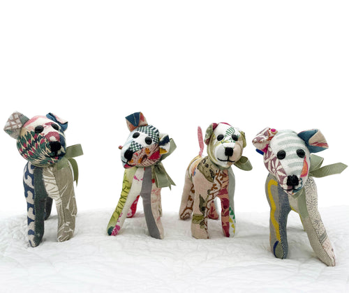 Group shot of 4 versions of the spring 2023 updated colours in Tiffany pooch, patchwork toy, standing on a white bedspread.