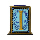 This black and gold alphabet box is decorated with a gold letter I in a heraldic decorative style, with a blue floral motif and embellished with a blue jewelled lid. 