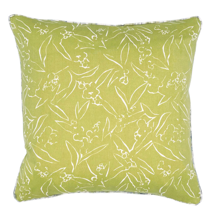 Lime green 45x45cm cushion, with simplified floral designs outlined in white, edged in white piping