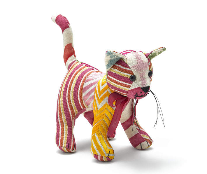 Our standing patchwork toy cat , called Kit Cat is made out of re-purposed fabrics from the Design team's interior projects this year, each of our Kit Cat's are unique, with this first limited run of 150, designed in off-cuts of fabric in pink and orange colour combinations making each cat is unique Size: height:18cm, ( from foot to top of ear - standing) w:22cm ( top of tail to nose).