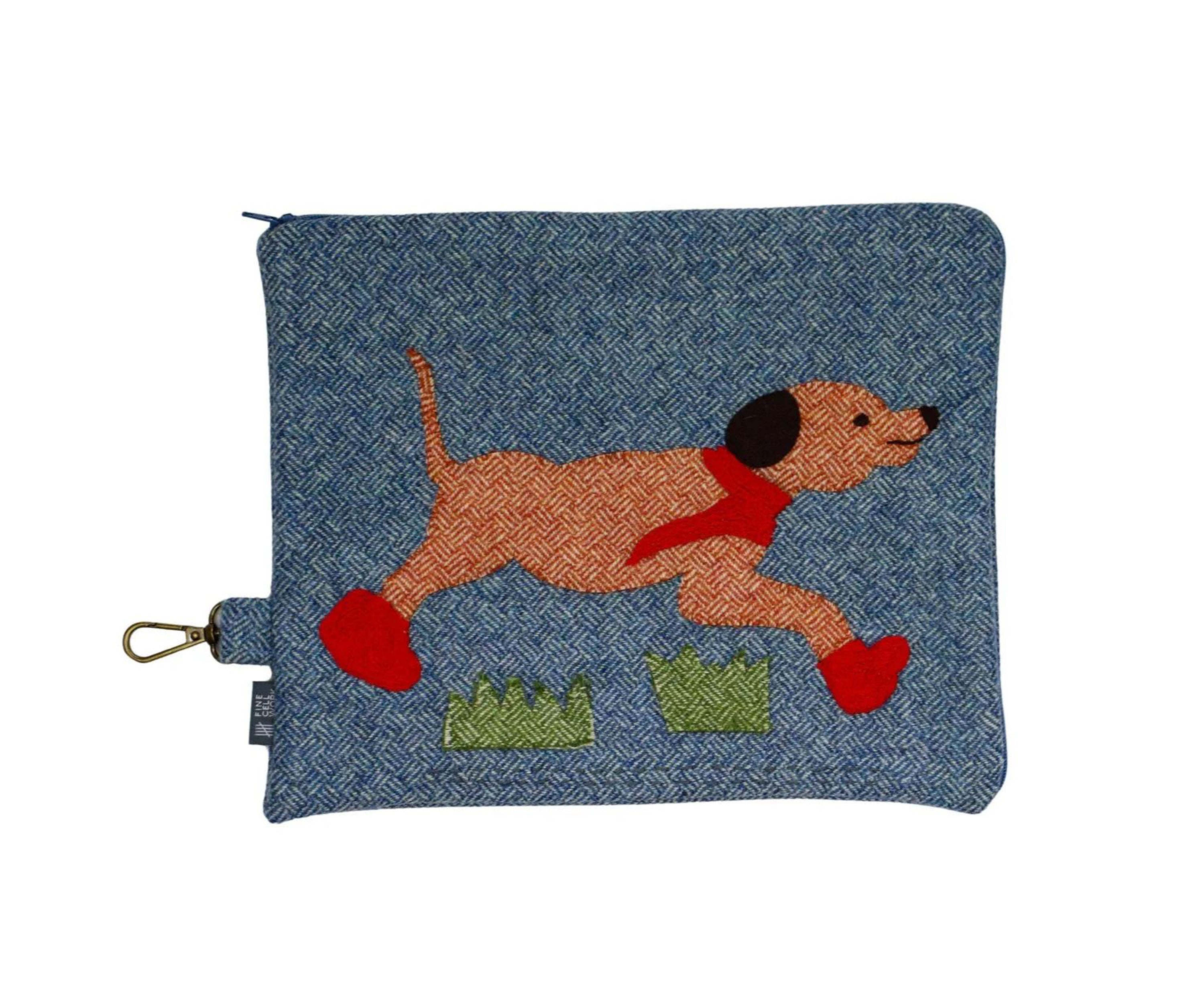 A playful Running Labrador pouch, with hand applique and embroidery. Ready for rainy weather the dog's bright red boots and matching scarf are detailed in flowing chain stitches, with running stitch and satin stitches highlighting its eyes, nose and mouth. A basket weave tweed fabric, in tones of rich denim, ember and green.