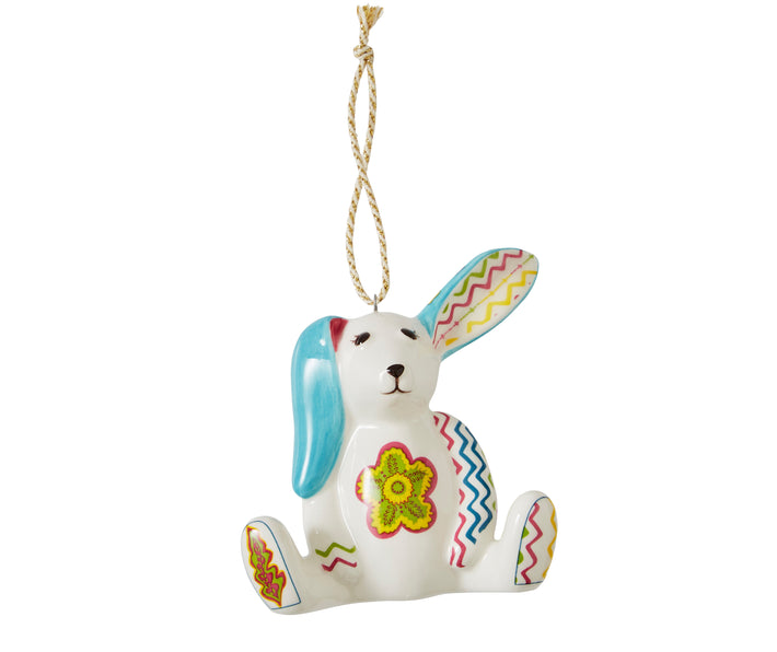 The Minnie seated rabbit ,white china ornament is inspired by Kit Kemp's patchwork toys and is decorated in bright pastel shades, with a large flower on it's belly, zig zag markings on its arms and feet , and floppy turquoise ears .